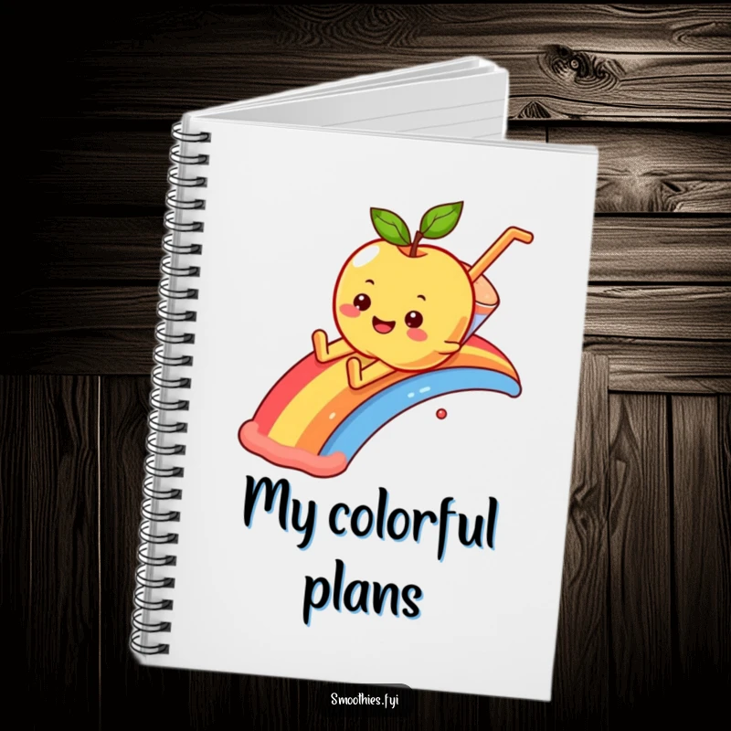 Funny smiling apple character sliding down a rainbow into a smoothie, featured on a notebook cover.